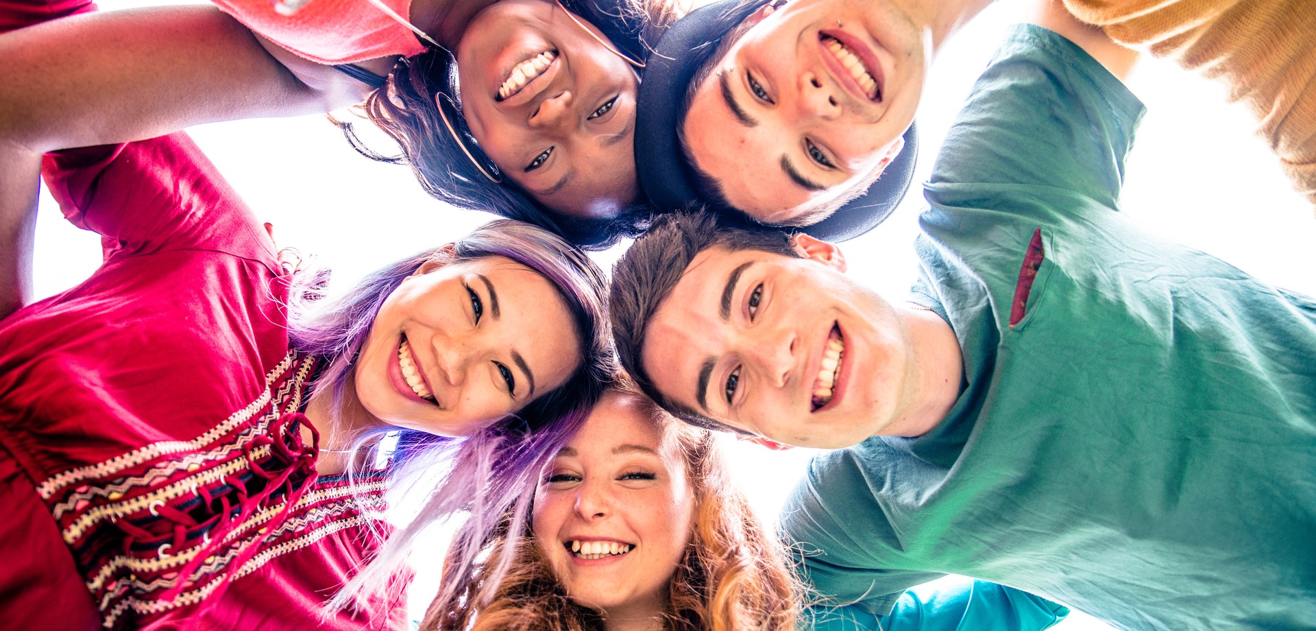 Foto von fünf Kindern und Jugendlichen, die glücklich in die Kamera lachen (Foto: AdobeStock/oneinchpunch).